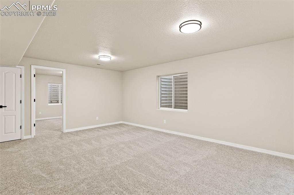 Image 20 of 27: Spare room featuring light carpet and a textured ceiling