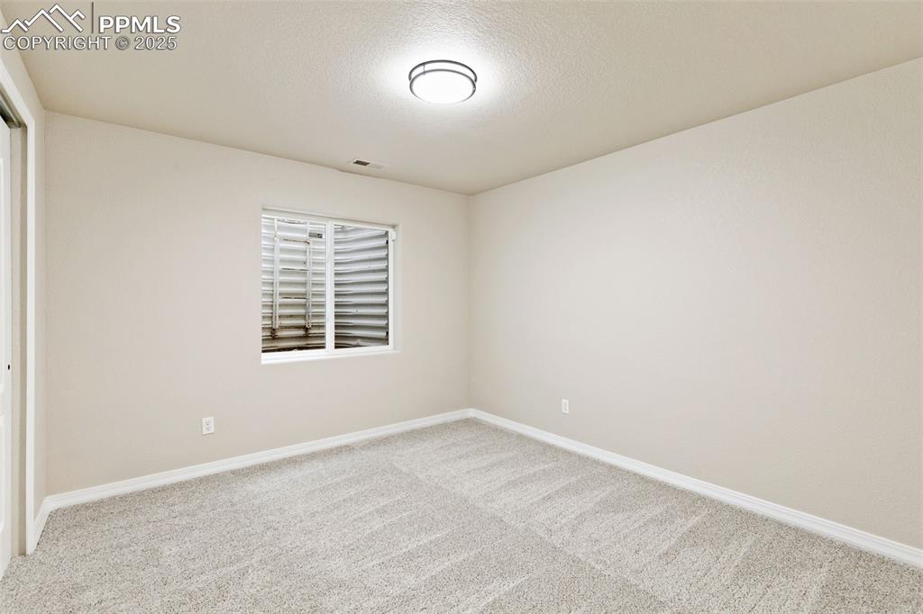 Image 23 of 27: Carpeted spare room featuring baseboards and a textured ceiling