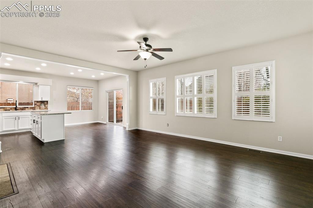 Image 3 of 27: Unfurnished living room featuring dark wood finished floors, recessed light