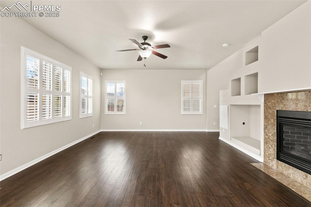 Image 6 of 27: Unfurnished living room featuring built in features, dark wood-style floors