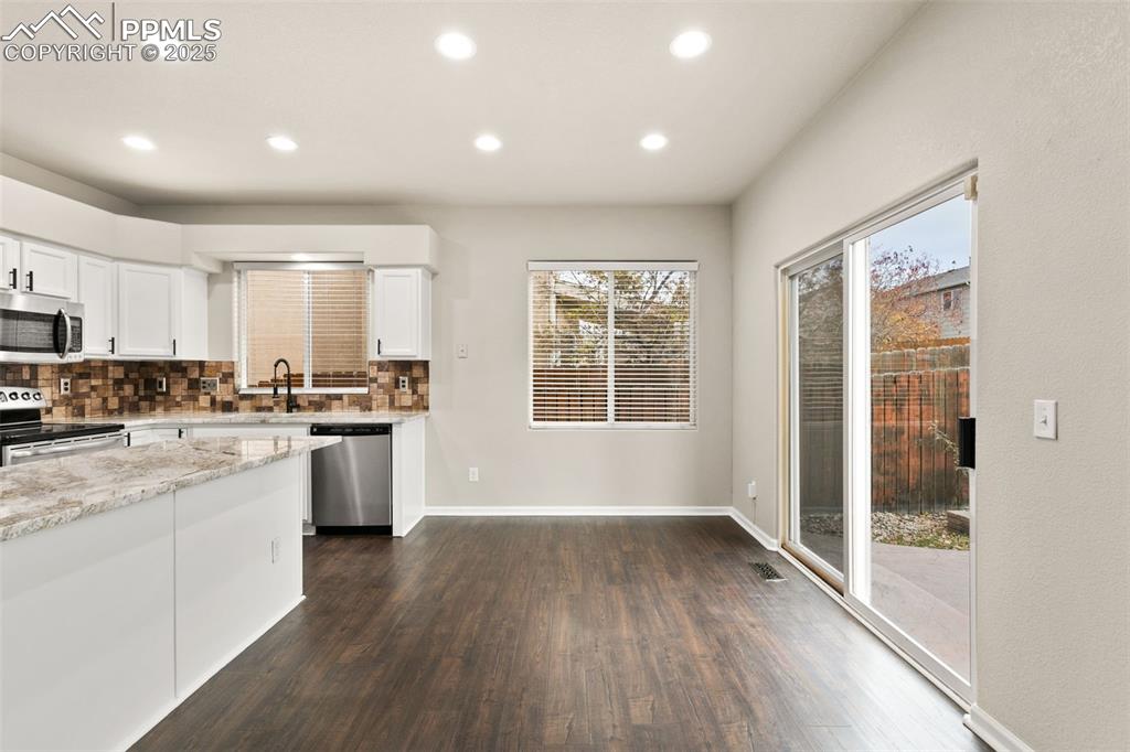 Image 7 of 27: Kitchen featuring white cabinets, tasteful backsplash, recessed lighting, l