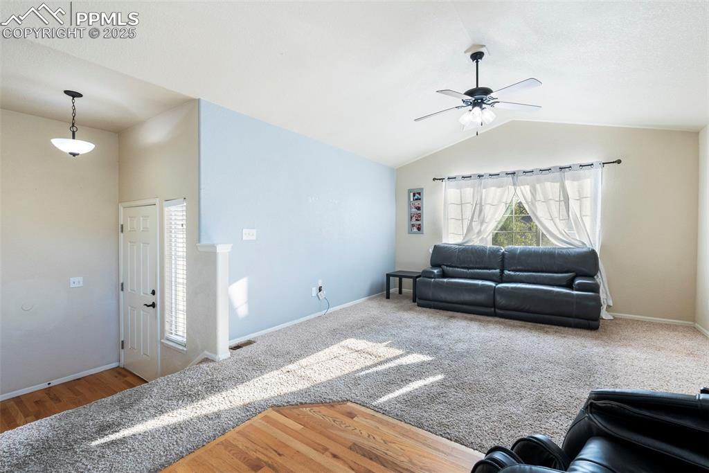 Image 14 of 46: Living room featuring, lofted ceiling, ceiling fan, and carpet flooring