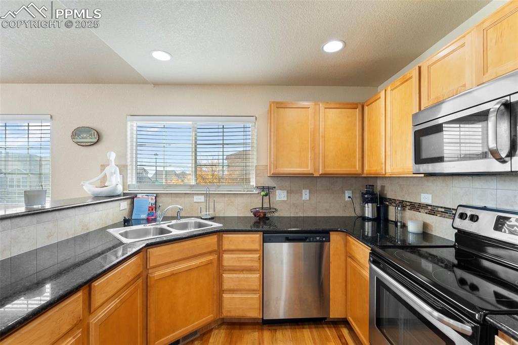 Image 20 of 46: Kitchen featuring stainless steel appliances, a textured ceiling, tasteful 