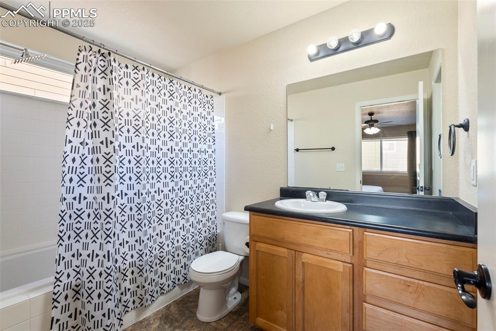 Image 27 of 46: Full bathroom with vanity, a textured wall, and a ceiling fan