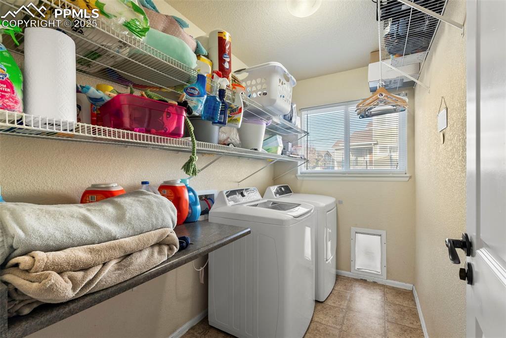 Image 34 of 46: Laundry room featuring independent washer and dryer, a textured wall, and a