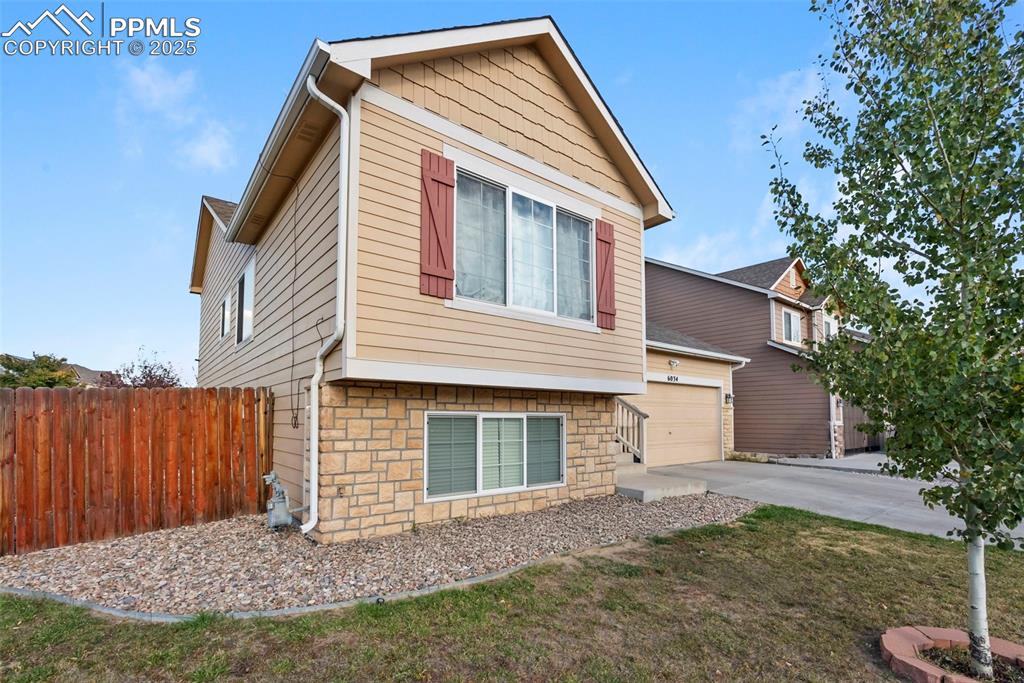 Image 4 of 46: View of front of property with a garage, driveway, and stone siding