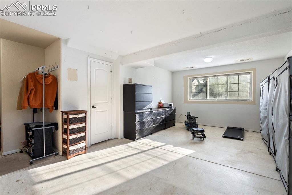 Image 40 of 46: Basement bedroom with concrete floors
