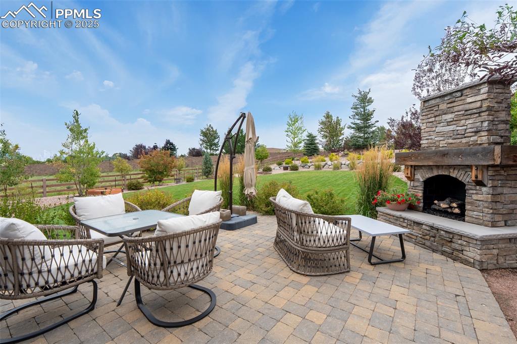 Image 37 of 50: Back patio with gas fireplace and built in stainless steel grill