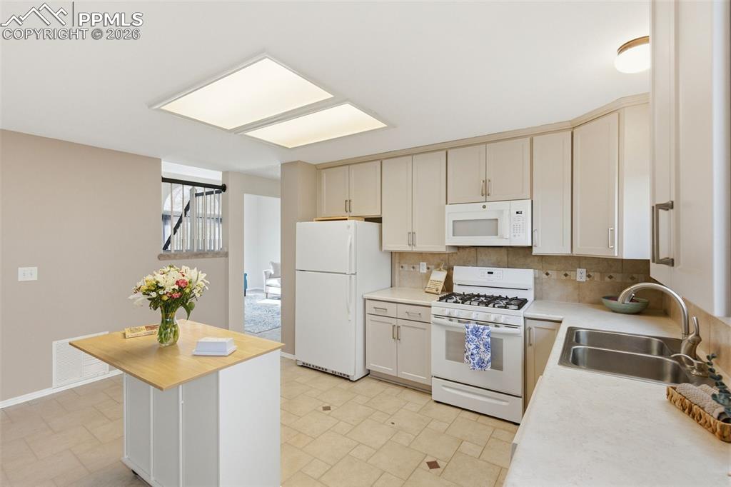 Image 10 of 46: Large kitchen with space for permanent island, new tile floor, and backspla