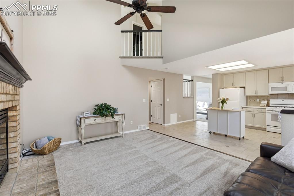 Image 12 of 46: Living area with lofted ceiling, healthy amount of natural light, and light