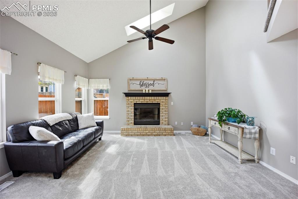 Image 13 of 46: Living area with lofted ceiling, 2 skylights, healthy amount of natural lig