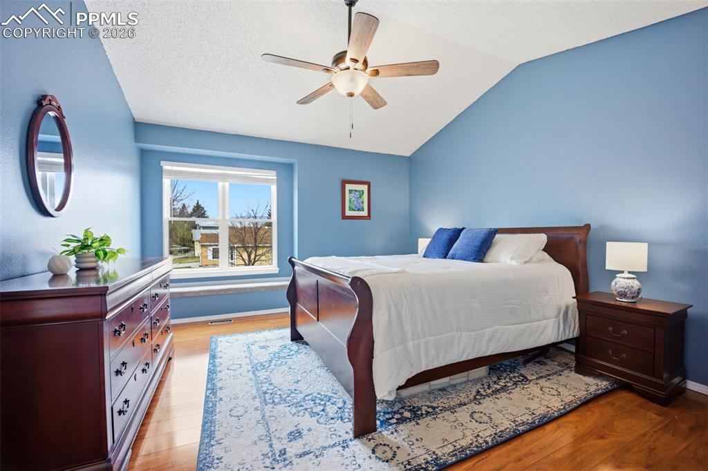 Image 15 of 46: Bedroom featuring light wood-style floors, a ceiling fan, and lofted ceilin