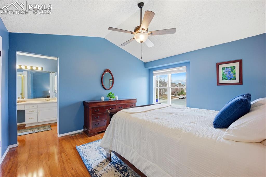 Image 16 of 46: Bedroom with light wood-style flooring, ensuite bath, and ceiling fan