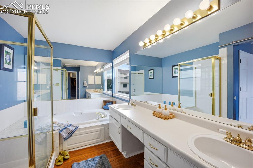 Image 19 of 46: Bathroom featuring a shower stall, double vanity, and jetted tub