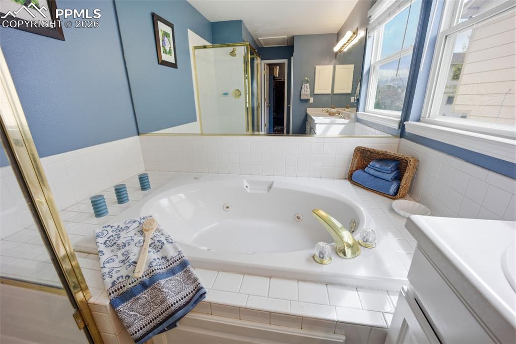 Image 20 of 46: Bathroom featuring a shower stall, double vanity, and jetted tub