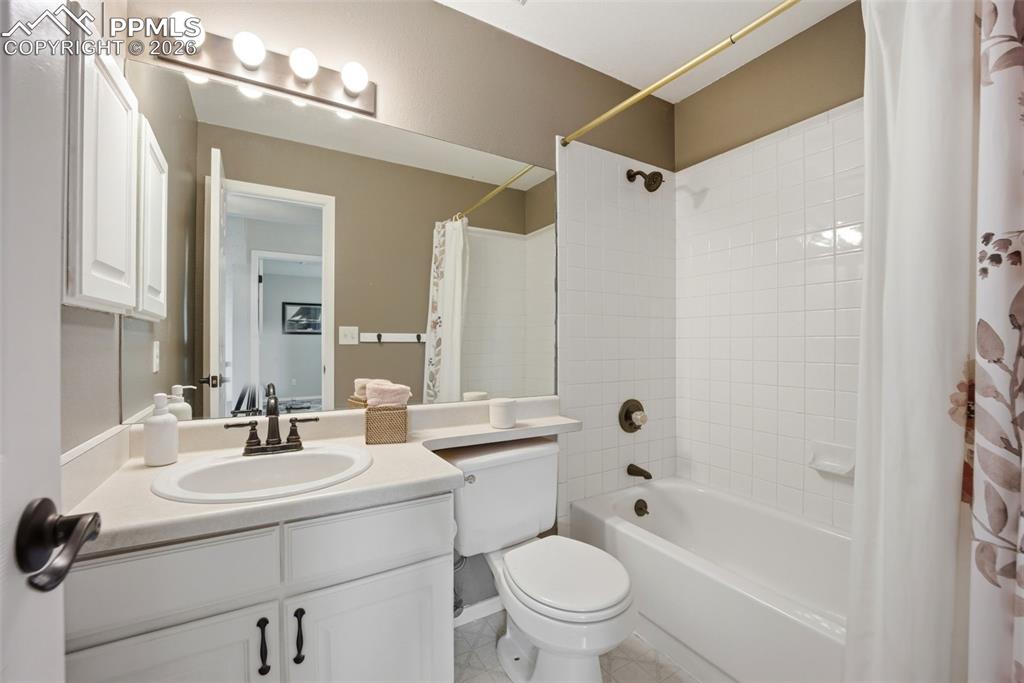 Image 24 of 46: Bathroom featuring vanity and shower / bathtub combination with curtain