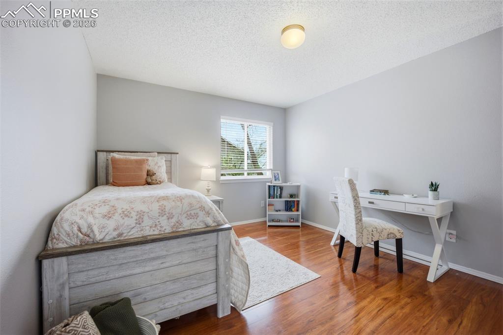 Image 26 of 46: Bedroom with a textured ceiling and wood finished floors