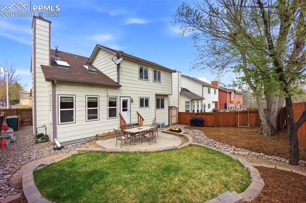 Image 3 of 46: Rear view of property featuring a patio, a chimney, a fenced backyard, and 