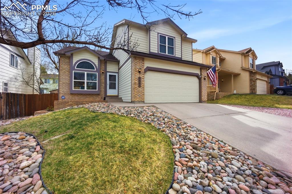 Image 38 of 46: Traditional-style home with brick siding, an attached garage, and driveway