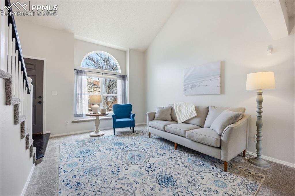 Image 5 of 46: Living room with lofted ceiling and light carpet