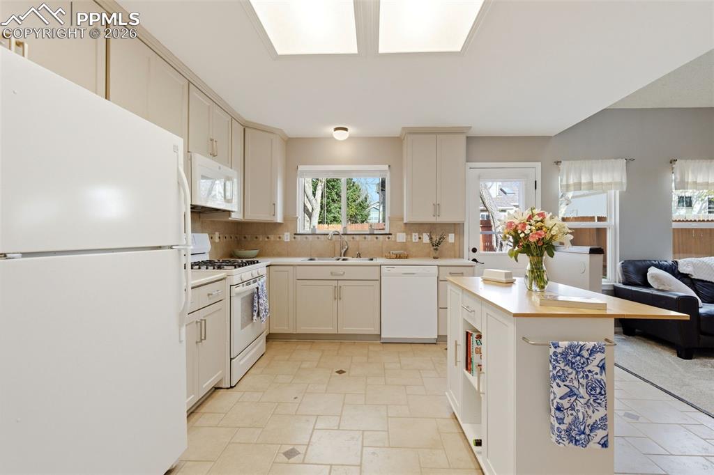 Image 9 of 46: Large kitchen with space for permanent island, new tile floor, and backspla