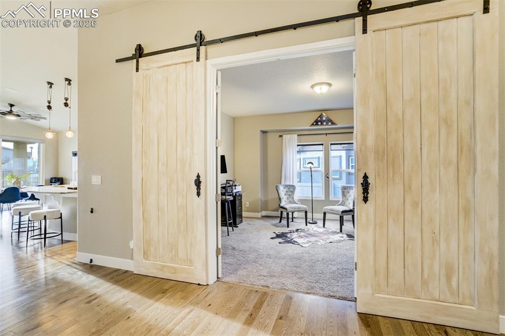 Image 14 of 49: Dual barn doors lead to a formal dining area or office