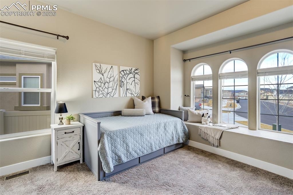 Image 24 of 49: Secondary bedroom on the main level with arched windows. 