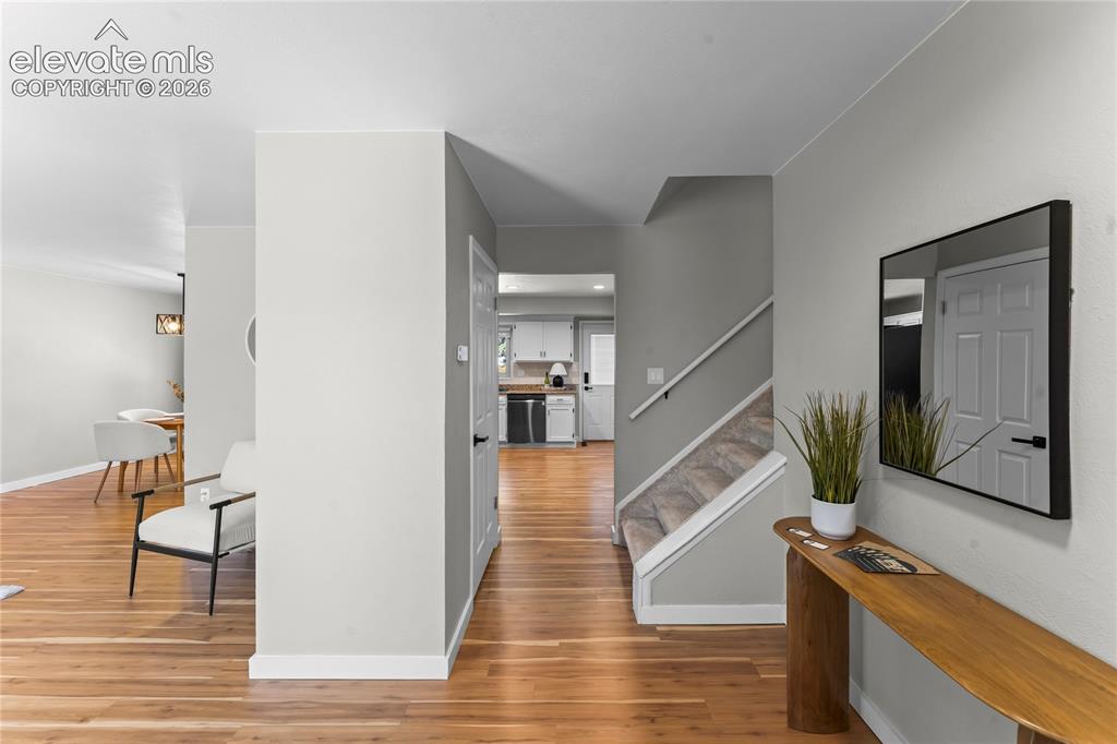 Image 17 of 50: Entryway featuring wood-finish flooring, light gray walls, and white basebo