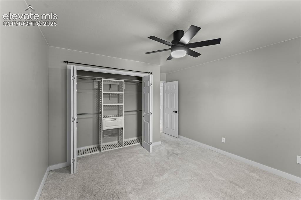 Image 23 of 50: Sophisticated third bedroom highlighted by a professional custom closet ins