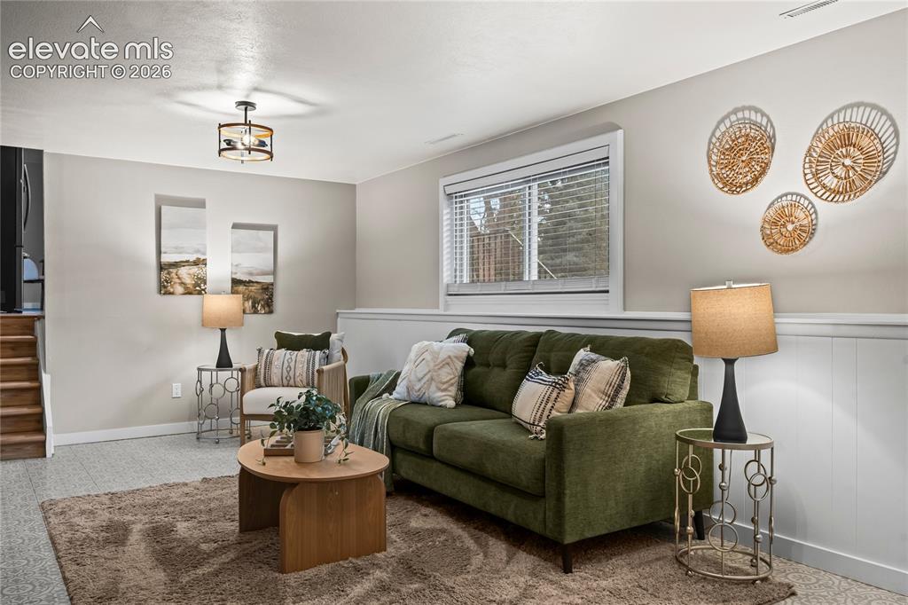 Image 29 of 50: Spacious living area featuring light-colored walls, patterned carpet floori