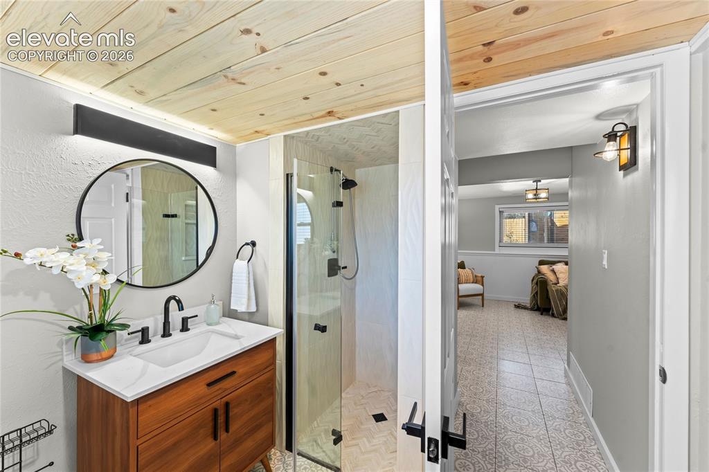 Image 34 of 50: The luxury continues in the third full bath, featuring a custom wood-finish