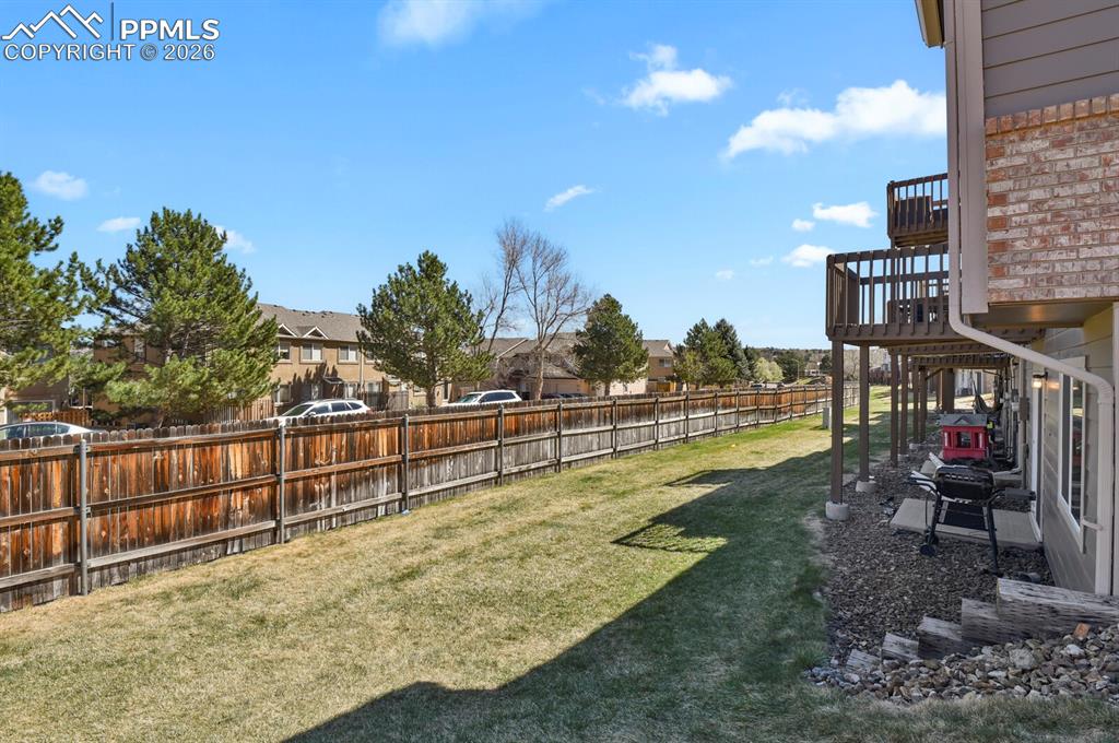 Image 18 of 19: Fenced backyard and a patio