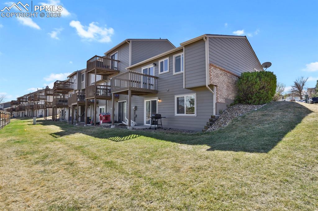Image 19 of 19: Rear of house featuring greenbelt, a patio, and a wooden deck