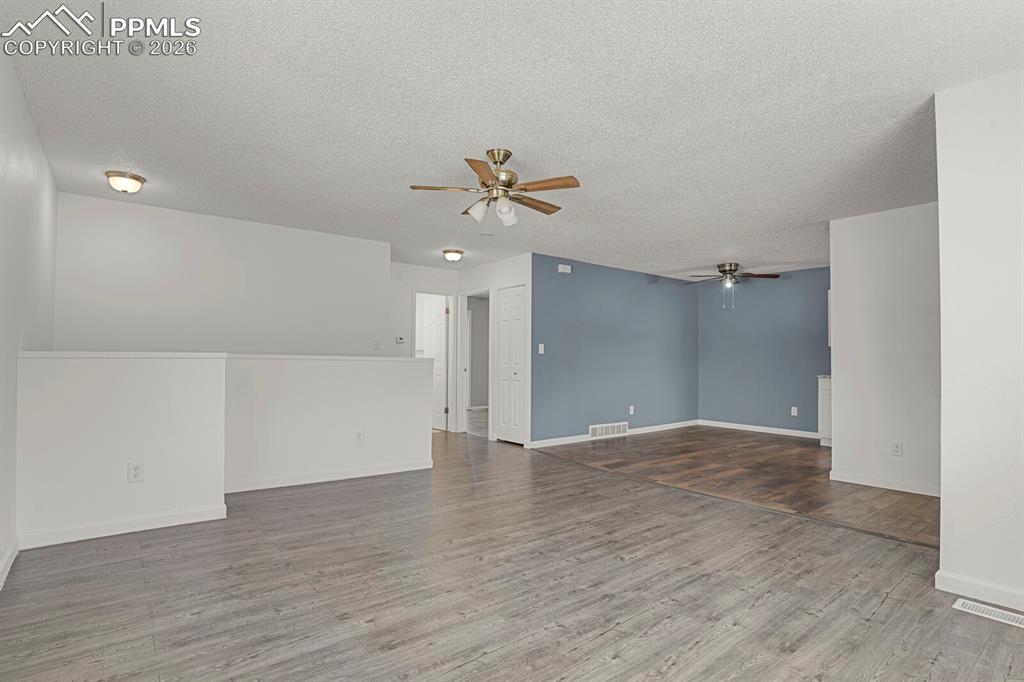 Image 5 of 19: Living room with a ceiling fan, Looking into the Dining Area and wood finis