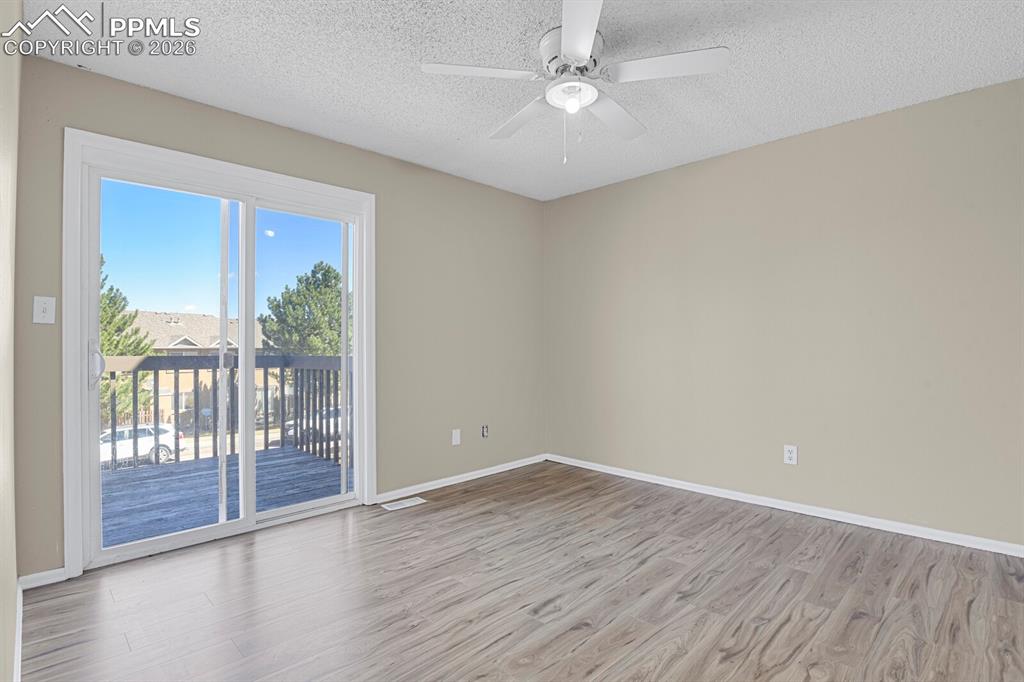Image 9 of 19: Bedroom room featuring ceiling fan, light wood-style flooring, and walk-out