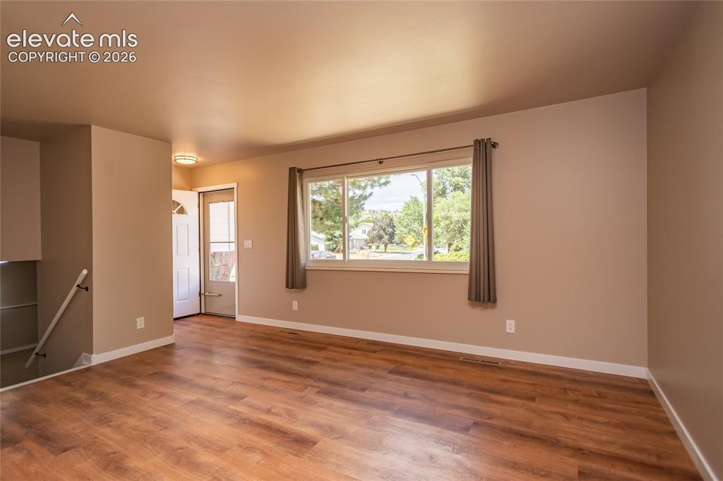 Image 2 of 46: Main level living room looking toward the front door.
