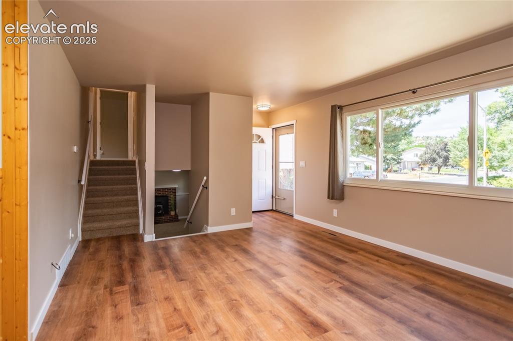 Image 25 of 46: Living room with stairs to upper level and down to lower level