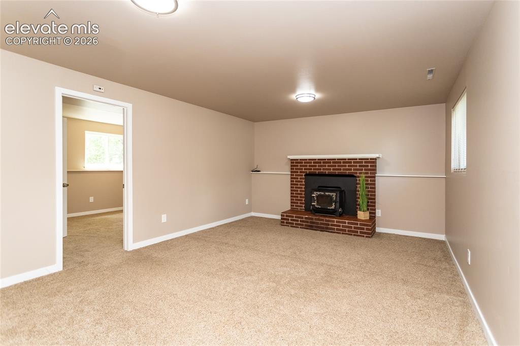 Image 27 of 46: Lower level family room with fireplace