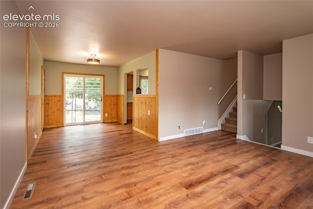 Image 8 of 46: Living room looking towards the dining area, kitchen, and backyard.