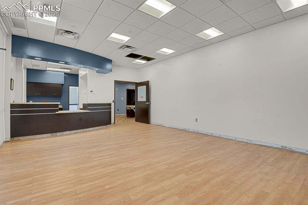 Image 15 of 50: Unfurnished living room with light wood-style floors and a drop ceiling