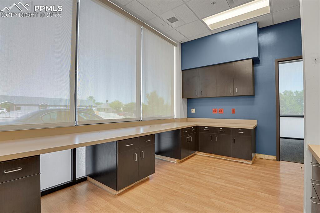 Image 17 of 50: Kitchen with a paneled ceiling, light wood-style floors, light countertops,
