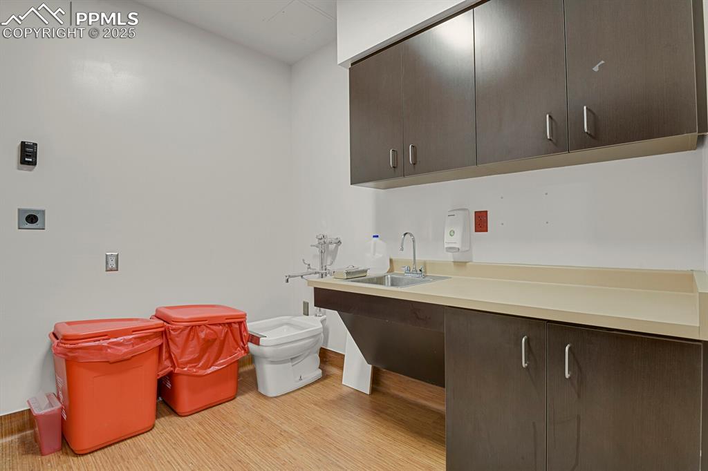 Image 21 of 50: Laundry area featuring cabinet space, electric dryer hookup, and wood finis