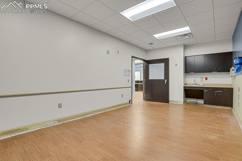Image 29 of 50: Unfurnished room with a drop ceiling and light wood-style floors