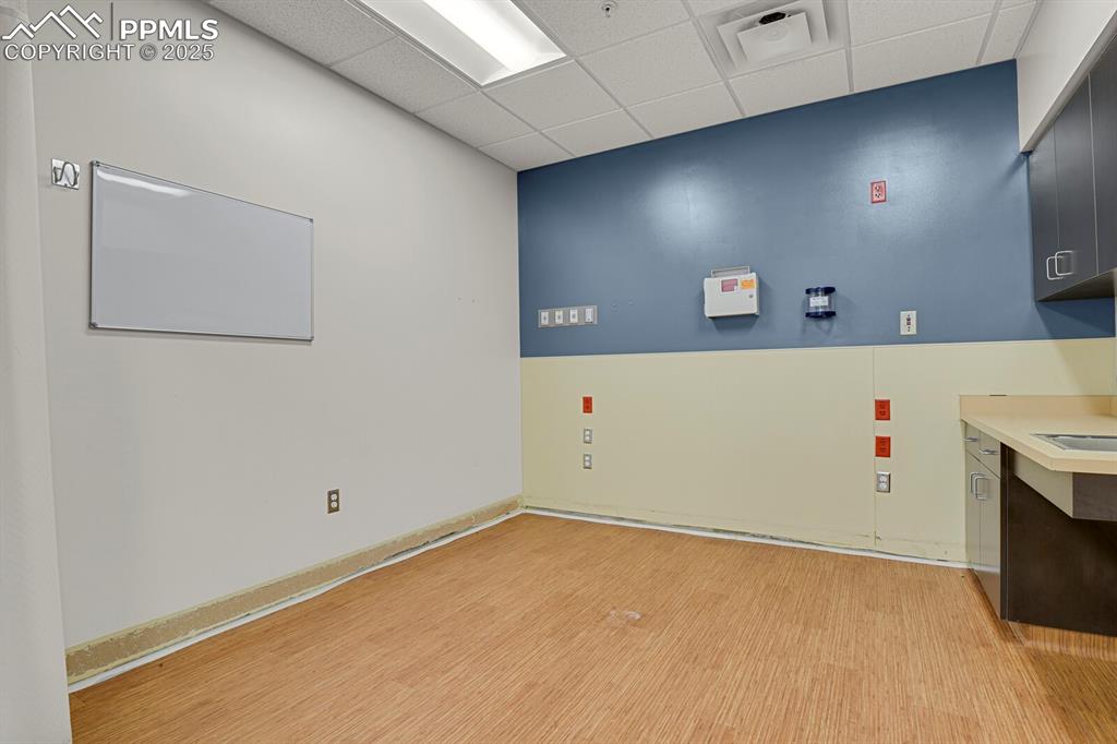 Image 31 of 50: Spare room featuring a paneled ceiling and light wood-style flooring