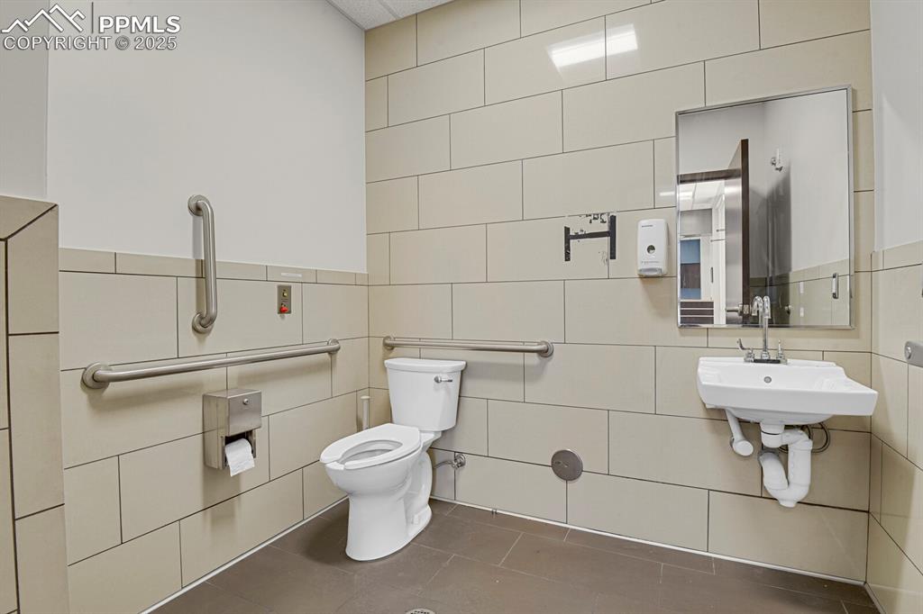 Image 9 of 50: Bathroom featuring tile walls and tile patterned floors