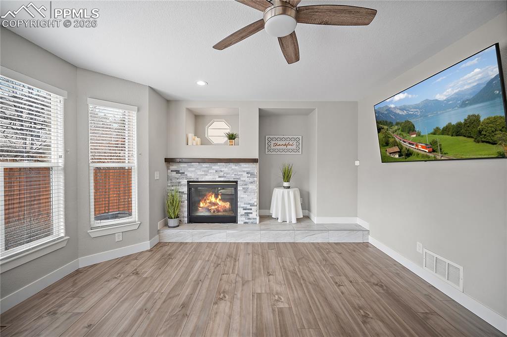 Image 16 of 46: Family room with gas fireplace and bay windows. 