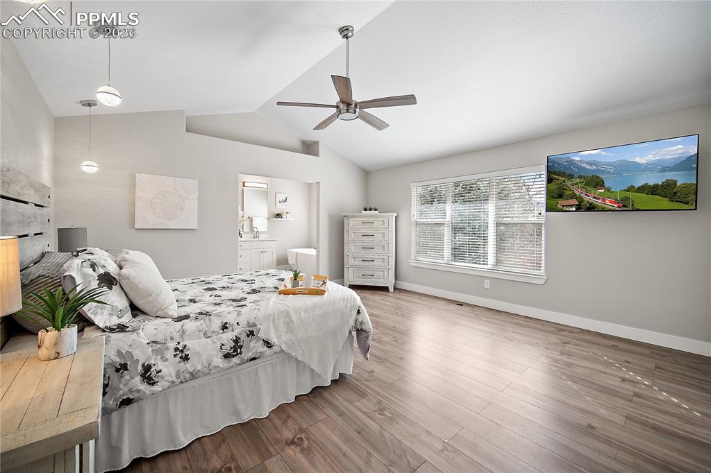 Image 22 of 46: Primary bedroom with vaulted ceilings, laminate flooring, new paint and lig