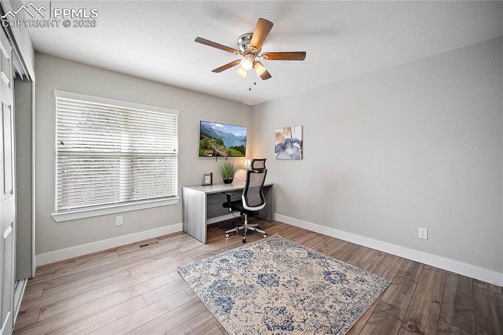 Image 29 of 46: Upstairs bedroom with laminate flooring. Currently being used as an office.