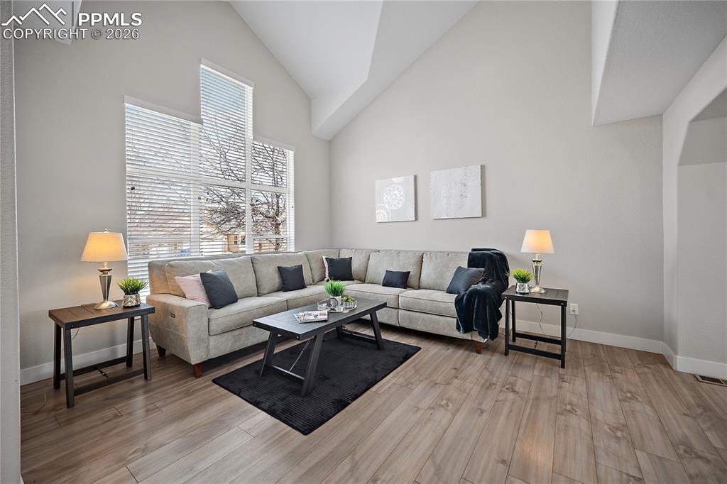 Image 5 of 46: Formal living room with laminate flooring, vaulted ceilings and tons of nat