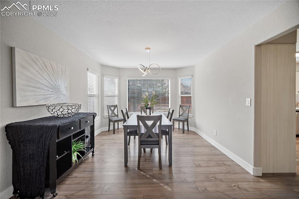 Image 8 of 46: Formal dining room with bay windows. Laminate flooring continues throughout